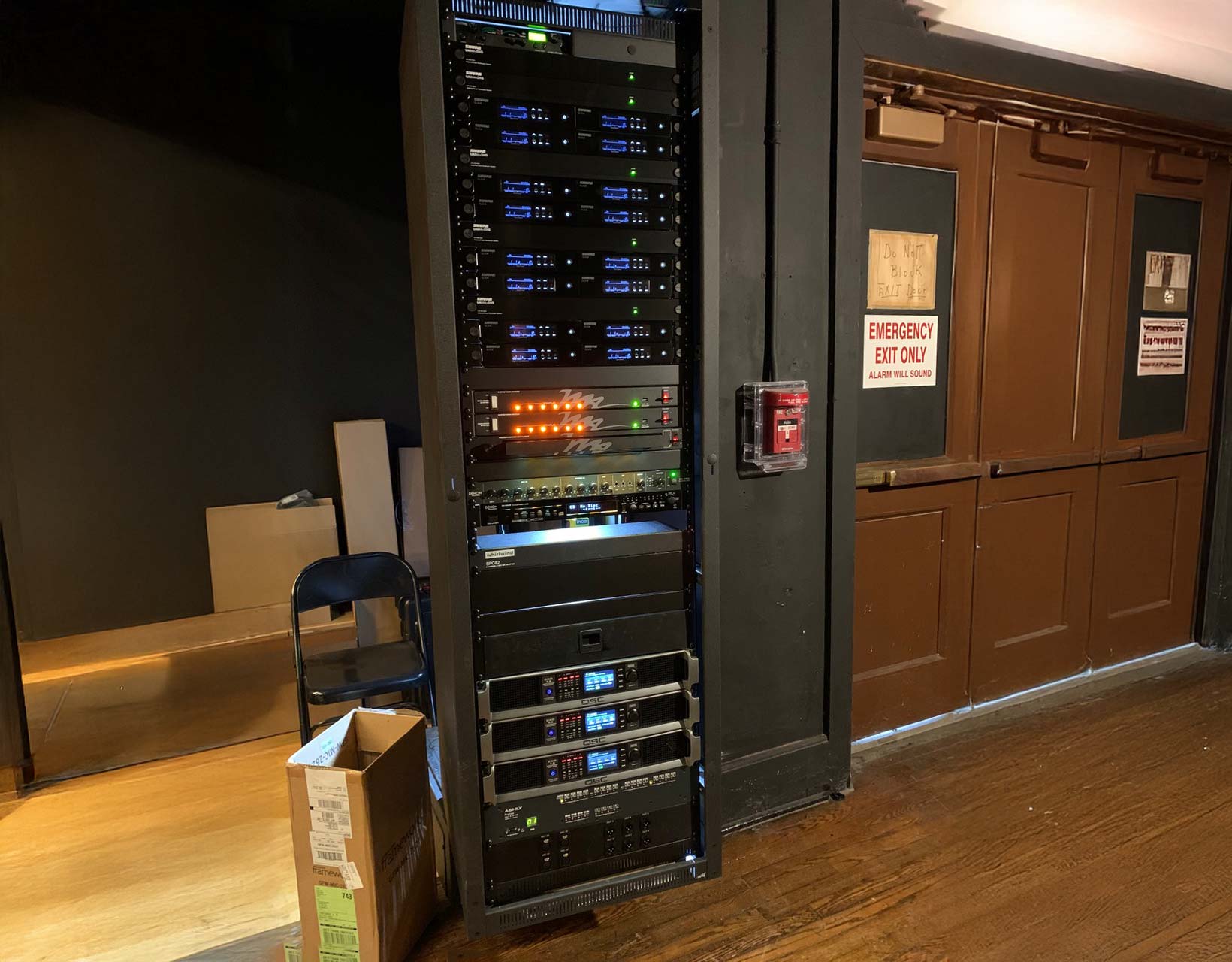 Professional audio equipment rack in a performance venue, showcasing amplifiers, processors, and power management systems installed by Pro Sound Associates.
